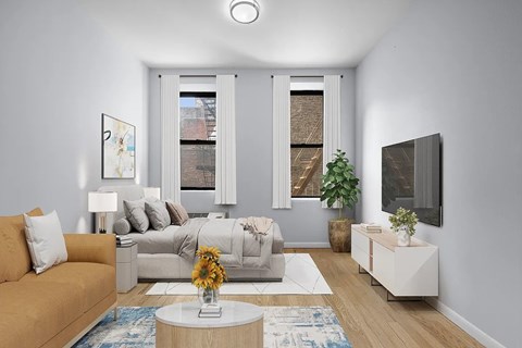 A living room with a couch, a bed, a coffee table, and a TV.
